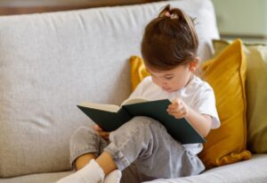 adorable little girl holding opened book while rel 2026 01 08 23 13 28 utc
